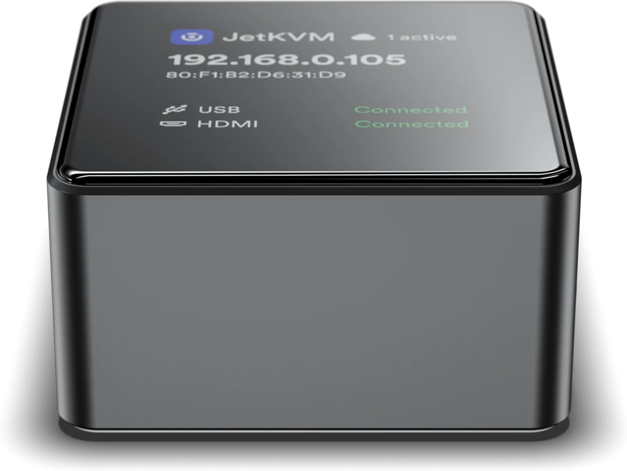 The JetKVM Mini, a small aluminium square device whose display shows the IP address, cloud connection and USB and video status.